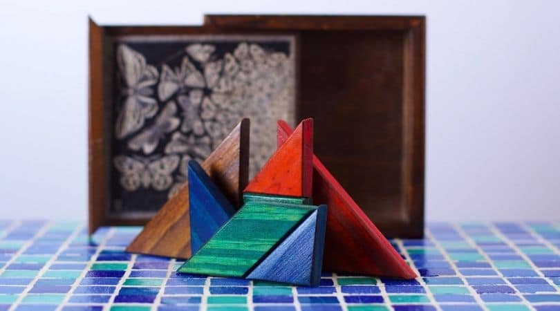 Peças de tangram dispostas na vertical sobre uma superfície de azulejos.