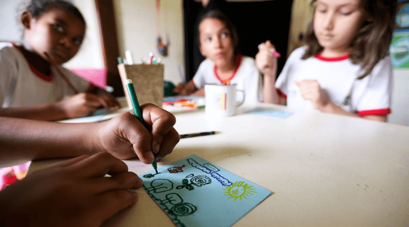 Foto de crianças em sala de aula, representando escolas que investem em uma boa alfabetização.